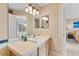 A well-lit bathroom with a large mirror, wood cabinets, and neutral countertops and walls at 1189 Fall River Cir, Longmont, CO 80504