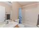 Bright bathroom featuring a shower-tub combo with blue curtain, toilet, sink and vanity at 1189 Fall River Cir, Longmont, CO 80504