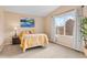 A bright bedroom featuring a large window, yellow bedding and neutral walls and carpet at 1189 Fall River Cir, Longmont, CO 80504