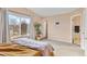 Bright main bedroom featuring a large window, tan carpet, a plant, and an en-suite bathroom at 1189 Fall River Cir, Longmont, CO 80504