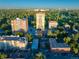 Wide aerial view of apartments, tree-lined streets, and a golf course set against a clear blue sky at 45 N Ogden St # 309, Denver, CO 80218