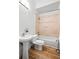 Bathroom with pedestal sink, tub/shower combo with light beige tile and wood flooring at 45 N Ogden St # 309, Denver, CO 80218