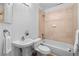 Bathroom with pedestal sink, tub/shower combo with light beige tile and wood flooring at 45 N Ogden St # 309, Denver, CO 80218