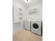 Bright laundry room with washer, dryer, storage, and neutral tile flooring at 45 N Ogden St # 309, Denver, CO 80218