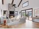Bright living room featuring a stone fireplace, wooden beams and lots of natural light and access to outdoor patio at 528 N Fuller Placer, Breckenridge, CO 80424