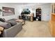 Finished basement area with a comfortable couch, a modern work station, and neutral carpet at 7722 E 6Th Pl, Denver, CO 80230
