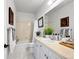 Bright bathroom featuring a shower over tub combination, white vanity, and marble floors at 7722 E 6Th Pl, Denver, CO 80230