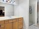 Bathroom showcasing a large mirror, wood vanity, and a glass door shower at 7722 E 6Th Pl, Denver, CO 80230