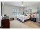 Comfortable bedroom with a ceiling fan, neutral tones, shuttered windows, and carpeted floor at 7722 E 6Th Pl, Denver, CO 80230