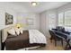 Cozy bedroom with comfortable bedding, shuttered window, and a writing desk with chair at 7722 E 6Th Pl, Denver, CO 80230