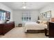 Spacious bedroom featuring a ceiling fan, shuttered window, carpet, and traditional-style furniture at 7722 E 6Th Pl, Denver, CO 80230