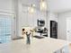 Bright kitchen with white cabinetry, modern appliances, and stylish pendant lighting at 7722 E 6Th Pl, Denver, CO 80230