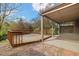 Back porch features wooden deck, covered patio, stone landscaping, and mature trees at 10868 W 70Th Ave, Arvada, CO 80004