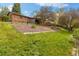 Backyard features lawn, rock garden, terraced garden beds, partial fence, and a brick home at 10868 W 70Th Ave, Arvada, CO 80004