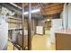 Unfinished basement features laundry area with washer and dryer hookups, utility sink, and storage cabinet at 10868 W 70Th Ave, Arvada, CO 80004
