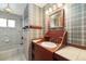Bathroom with tiled shower/tub, sink, and plaid wallpaper at 10868 W 70Th Ave, Arvada, CO 80004