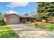 Charming brick home with a well-maintained front yard and a long driveway leading to the garage at 10868 W 70Th Ave, Arvada, CO 80004