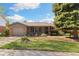 Charming single-story home with brick accents, manicured lawn, mature trees, and attached garage at 10868 W 70Th Ave, Arvada, CO 80004