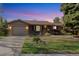 Charming single-story home with a well-maintained lawn and landscaping, lit by evening's glow at 10868 W 70Th Ave, Arvada, CO 80004