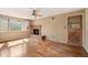 Cozy living room featuring hardwood floors, a brick fireplace, and a ceiling fan at 10868 W 70Th Ave, Arvada, CO 80004