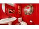 Compact half bathroom features red walls, modern fixtures, and decor at 2334 Yosemite St, Denver, CO 80238