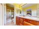 Well-lit bathroom with double vanity, wooden cabinets, and a glass-enclosed shower at 2334 Yosemite St, Denver, CO 80238