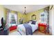 Charming bedroom with a statement chandelier, red accents, and a large window at 2334 Yosemite St, Denver, CO 80238