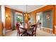 Inviting dining room with a wooden table, large window, and stylish orange walls at 2334 Yosemite St, Denver, CO 80238