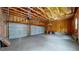 Spacious garage with two large doors, exposed beams, and ample room for vehicles and storage at 2334 Yosemite St, Denver, CO 80238