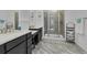 Modern bathroom with dual sinks, dark cabinets, a glass-enclosed shower, and tiled floor at 5045 Preserve Pl, Firestone, CO 80504