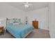 Bedroom with bed and matching side tables, a ceiling fan, and view of the entrance door at 5045 Preserve Pl, Firestone, CO 80504