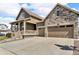 Well-maintained two-story home with a combination of siding and stone facade, two-car garage, and a manicured lawn at 5045 Preserve Pl, Firestone, CO 80504