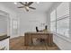 Bright home office featuring wood floors, plantation shutters, ceiling fan and a modern wood desk at 5045 Preserve Pl, Firestone, CO 80504