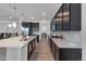 Spacious kitchen featuring a large island with a sink, dark cabinetry, and stainless steel appliances at 5045 Preserve Pl, Firestone, CO 80504