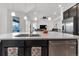 Stylish kitchen island with a sink and stainless steel dishwasher, open to the bright living area at 5045 Preserve Pl, Firestone, CO 80504