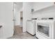Bright laundry room with new washer and dryer, shelving, and tile floor at 5045 Preserve Pl, Firestone, CO 80504
