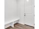 Mudroom featuring wood floors, white bench seating and bright natural light at 5045 Preserve Pl, Firestone, CO 80504