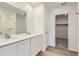 Modern bathroom featuring dual sinks, a large mirror, and walk-in closet at 21935 E 39Th Pl, Aurora, CO 80019