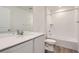 Bright white bathroom features a shower-tub combo, vanity with undermount sink, and wood-look flooring at 21935 E 39Th Pl, Aurora, CO 80019