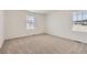 A clean and bright bedroom featuring two windows and plush carpet flooring at 21935 E 39Th Pl, Aurora, CO 80019