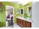 Bright bathroom with a dual sink vanity, white countertop, and decorative mirrors, leading to the bedroom at 21062 E Mansfield Pl, Aurora, CO 80013