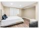 Bedroom with hardwood flooring, a queen-size bed with a white comforter, and a modern arched alcove at 21062 E Mansfield Pl, Aurora, CO 80013