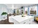 Open concept space with hardwood floors, a white island, and several windows providing lots of natural light at 21062 E Mansfield Pl, Aurora, CO 80013