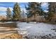 Snowy backyard with a wooden fence and mature trees at 4638 S Mobile Way, Aurora, CO 80015