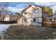 Back exterior of a two-story home featuring a small dog house and partially snow-covered yard at 4638 S Mobile Way, Aurora, CO 80015