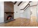 Bright living room boasting a brick fireplace, hardwood floors, vaulted ceilings, and exposed wooden beams at 4638 S Mobile Way, Aurora, CO 80015