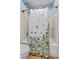 Bathroom with floral shower curtain, toilet, and combination shower and bathtub at 18771 Mexico E Dr, Aurora, CO 80017