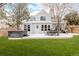 Landscaped backyard with a patio, outdoor dining set, a hot tub, and lush green grass at 8827 Cactus Flower Way, Highlands Ranch, CO 80126