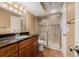 Bathroom featuring a granite countertop, wood cabinets, and a glass-enclosed shower at 8827 Cactus Flower Way, Highlands Ranch, CO 80126