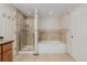 Modern bathroom with a tiled shower, tub, and neutral colors at 8827 Cactus Flower Way, Highlands Ranch, CO 80126